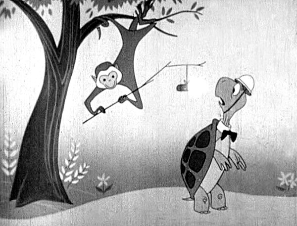 A black and white cartoon turtle looks in alarm as a cheeky monkey hangs from a tree, holding out a stick from which is dangling a lit stick of TNT.  